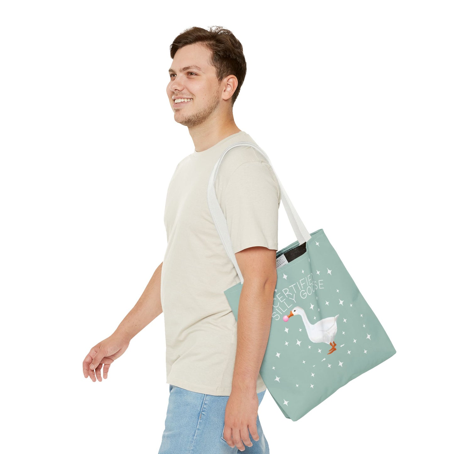 Man carrying a green tote bag with a duck design on a white background