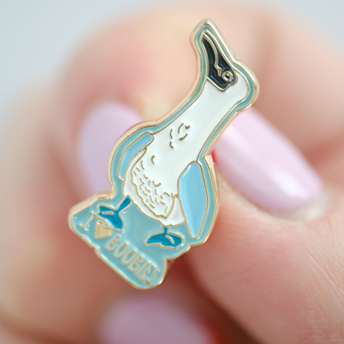 Close-up of blue-Footed Booby enamel pin with I Love Boobies lettering.