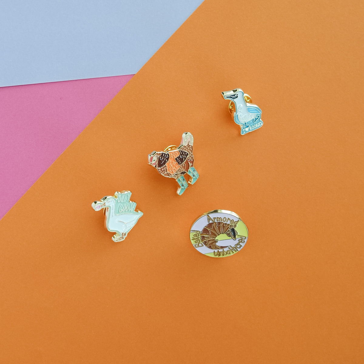Assorted Acorn & Artisan enamel pins including the Blue-Footed Boobie Enamel Pin