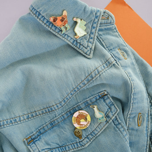 Blue-Footed Boobie Enamel Pin styled in a colorful lifestyle setting