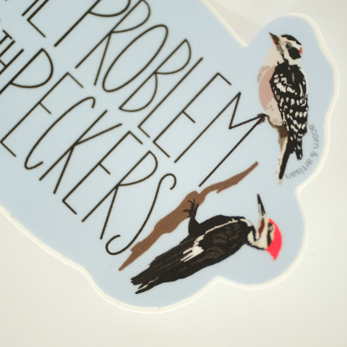 Close-up of the Problem with Peckers vinyl sticker with illustrated woodpeckers.