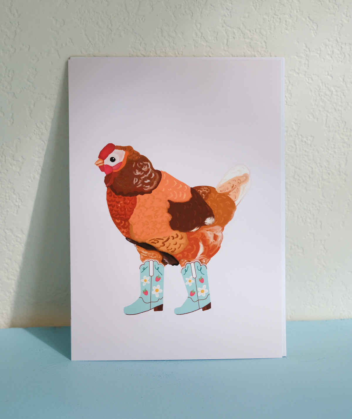 Cowgirl Chicken Art Print featuring a chicken wearing mint green strawberry-patterned cowgirl boots.