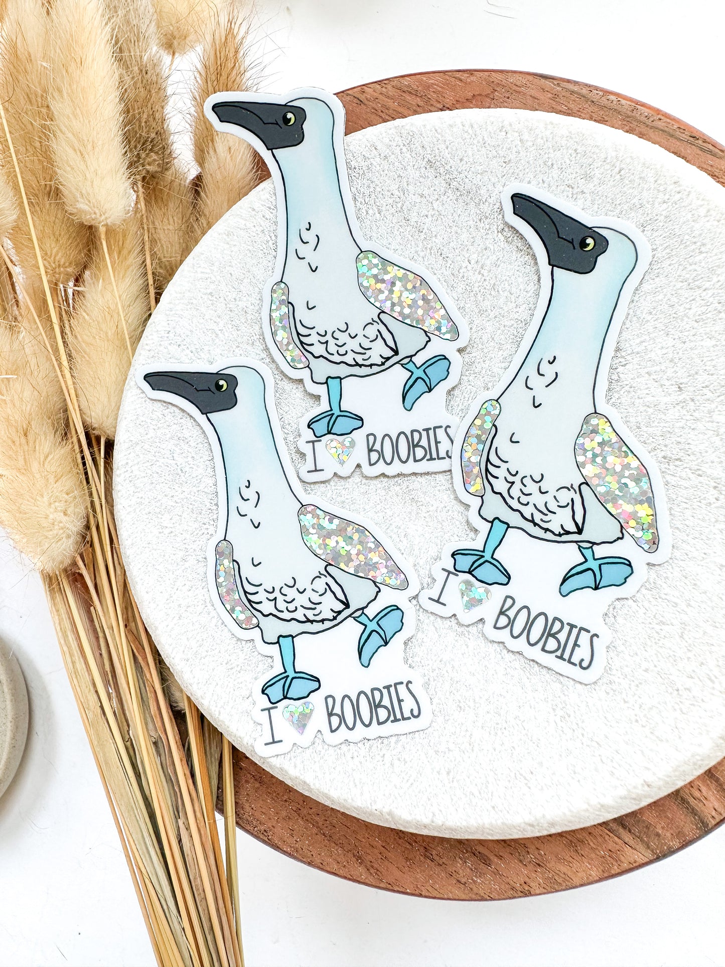 Blue footed boobie sticker with text below: I heart boobies. Wings of the birds are glitter.