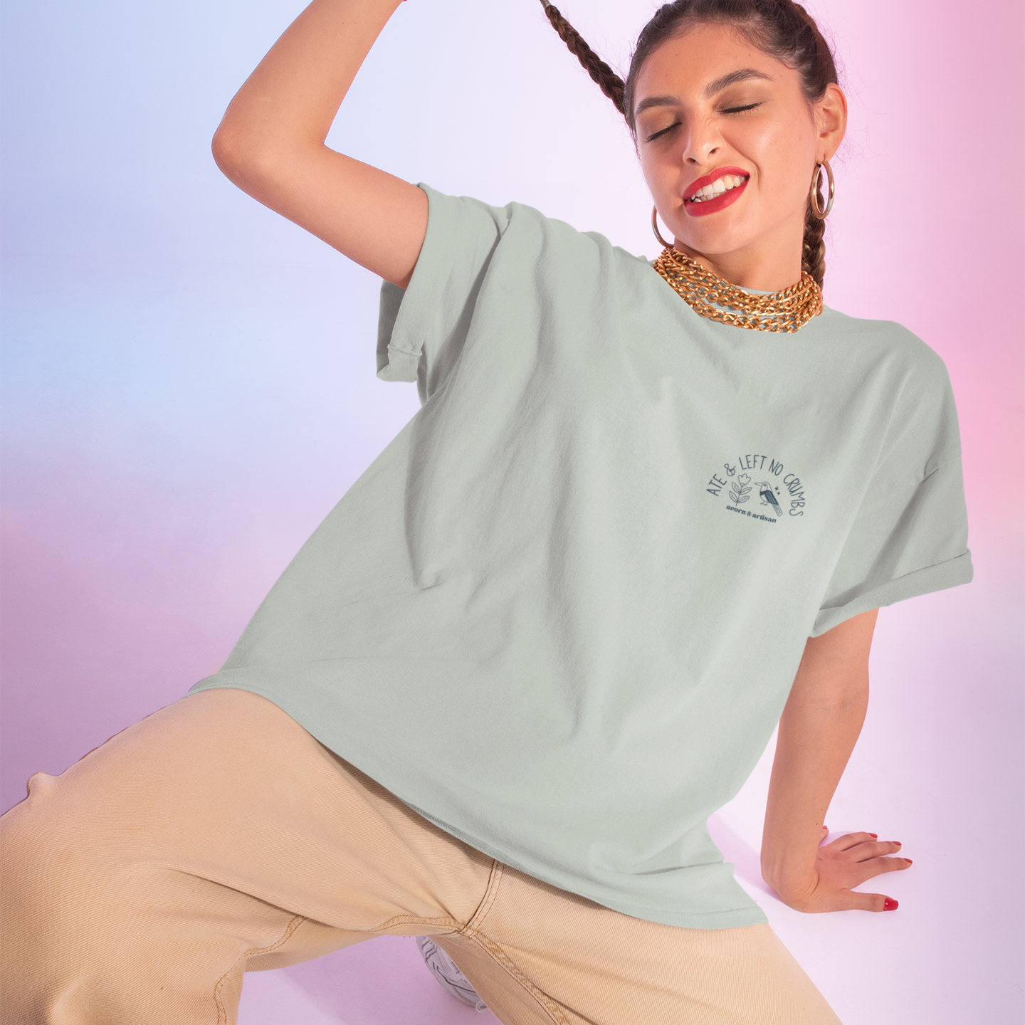 Woman in a light green t-shirt and beige pants posing against a gradient background