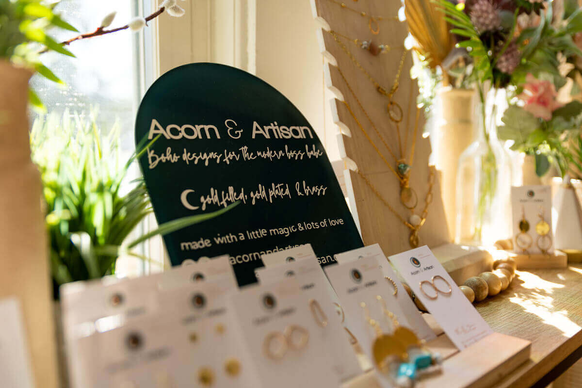 Acorn and Artisan sign with earrings in front