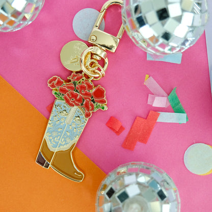 Poppy Cowgirl Boot Enamel Keychain styled in a colorful lifestyle setting