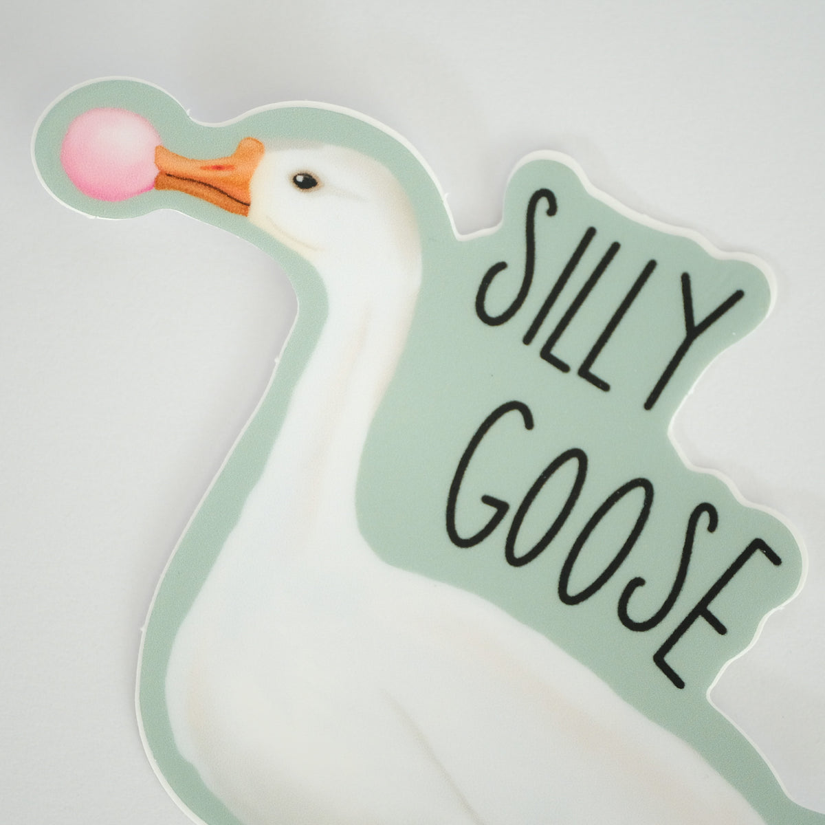 Close-up of silly Goose vinyl sticker with a white goose blowing pink bubblegum.